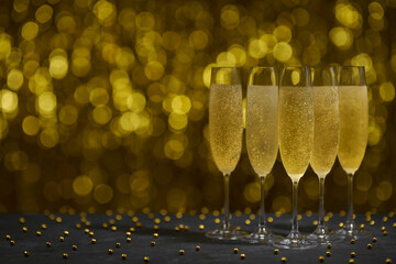 Glasses of champagne on gold background, copy space for text.