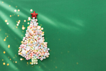 Wall Mural - New Year and Christmas card. Abstract Christmas tree from colorful marshmallows on green background