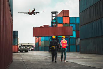 Wall Mural - Industrial worker works with co-worker at overseas shipping container port . Logistics supply chain management and international goods export concept .