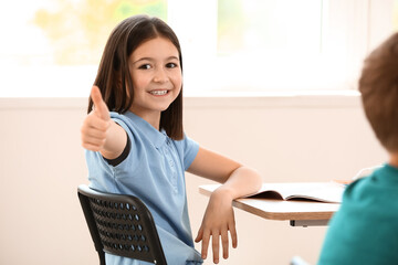 Wall Mural - Pupil showing thumb-up while taking classes at language school