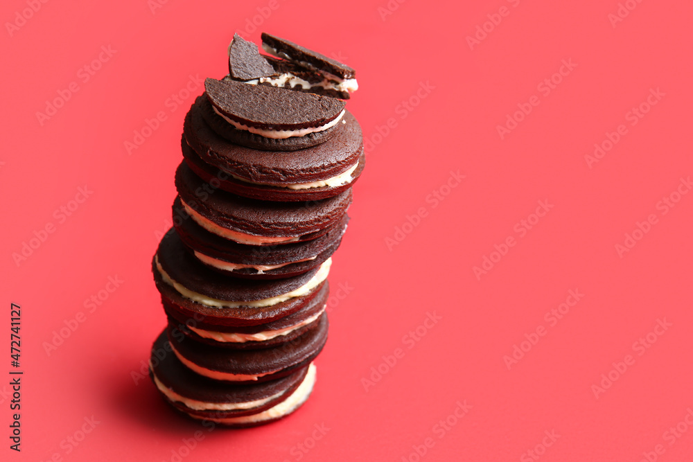 Tasty chocolate cookies with cream on red background