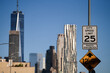 New York, USA - 2021: Traffic sign indicating the speed limit as 25mph at the entrance to Manhattan. One World Trade Center office building and other skyscrapers are in background.