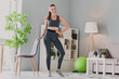 Photo of charming pretty girl dressed sport suit practicing aerobics smiling indoors house home