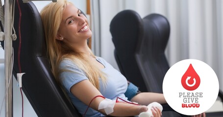 Poster - Portrait of smiling young woman donating blood sitting on chair by symbol at hospital