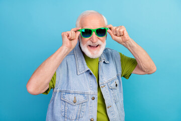 Canvas Print - Photo of cool pretty retired man wear vintage jeans waistcoat arms dark glasses smiling isolated blue color background