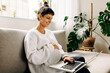 © (JLco) Julia Amaral - Happy pregnant woman video calling her friends at home