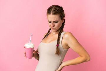 Wall Mural - Young woman with strawberry milkshake isolated on pink background suffering from backache for having made an effort