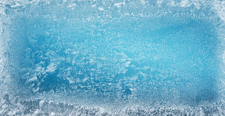 Frost patterns on frozen winter window as a symbol of Christmas wonder. Christmas or New year background.