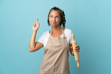 Wall Mural - Middle age woman in chef uniform with fingers crossing and wishing the best