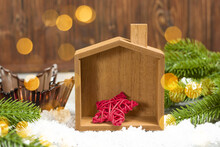 Concept For A Greeting Card With  Wooden House, Tree And Red Star For Christmas. Soft Focus, Light Golden Bokeh.