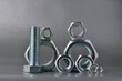 composition of new bolts and nuts of different sizes on a gray background.