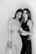 © kalinichenkod - Two sports girls posing isolated on a white background. Fitness model woman in studio with copy space