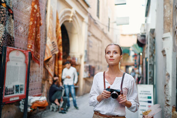 Wall Mural - Tourism and technology. Happy young woman taking photo of  Marrakesh old town. Traveling by Morocco.