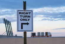 Right Turn Only Sign On Top Of Parking Garage At Dusk
