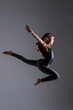 © VictorHugo - young woman doing artistic gymnastics jumps, wearing gym clothes, photo taken in a studio.