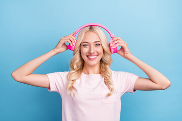 Poster - Photo of cute young blond lady listen music wear pink t-shirt isolated on blue color background