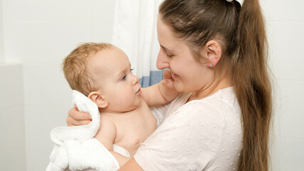 Wall Mural - Portrait of smiling baby boy and mother after washing in bathroom at home