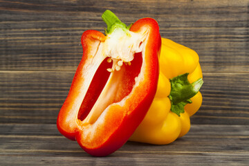 Poster - Yellow and red peppers on a wooden background.