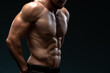 © speed300 - Cropped view of the male body with perfect abs posing isolated on black background. Strong athletic man fitness model