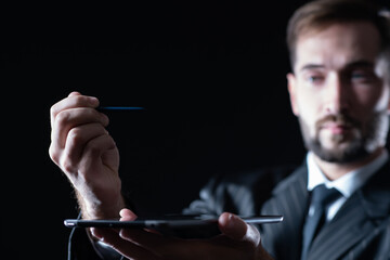Poster - tablet and stylus on the background of a blurry man face. the businessman is holding a tablet. a mal