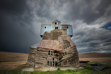 Wall Mural - Old grain mill and storm clouds, Palouse region of eastern Washington.