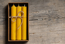 Yellow Beeswax Candles In A Cardboard Box, Top View. Copy Space For Text.