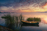 Fototapeta Pomosty - Boat on the lake in the rays of the rising sun and fog, zemborzycki lake