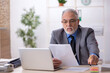 © Elnur - Old male employee working in the office