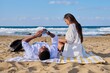 © Valerii Honcharuk - Young multicultural couple lying on the beach using smartphones