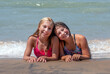 Best of friends on the beach, two young girls realx on e shore of Lake Michigan