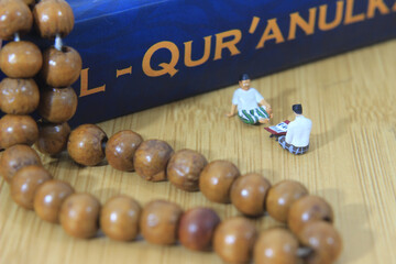 Wall Mural - Simple Conceptual Photo, Islam Man or Muslim, Learn Read Al Quran, Al Qur'an Near The Real One and Wooden Prayer Bead, with his teacher