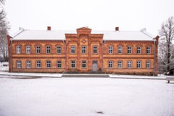 Canvas Print - Old red brick school in snowy winter day, Vecumnieki, Latvia