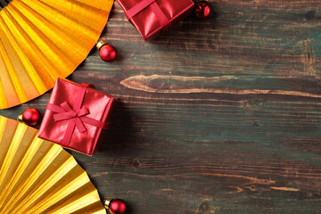 Poster - Christmas red gift box and golden fan decoration on table wood background