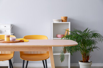 Dining table with reed diffuser and candle in interior of light room