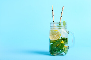  Mason jar of cocktail with mint and lemon on color background