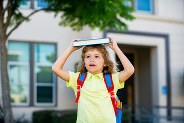 Happy smiling kid in glasses is going to school for the first time. Pupil go study. Child boy with bag go to elementary school. Child of primary school. Back to school. Kids education concept.