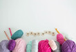 colourful woolen yarn balls with crochet hooks and wooden letters and space for text