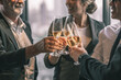 © Attayoot - Picture of young business man and woman talking to his older business partner. They are in white shirt and black tie. They are sitting on a table in a hotel lobby. They are holding a champagne glass.