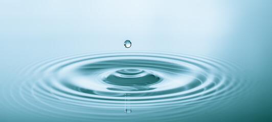 Wall Mural - splash of water droplets on a smooth water surface