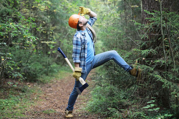 Wall Mural - Male lumberjack in the forest. A professional woodcutter inspects trees for felling.