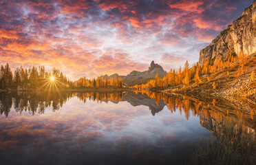 Incredible purple sunrise on Federa Lake in the Dolomite Apls. Autumn mountains landscape with Lago di Federa and bright orange larches, Cortina D'Ampezzo, South Tyrol, Dolomites, Italy