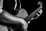 Fototapeta  - Hombre elegante tocando la guitarra clásica. Fotografía en blanco y negro
