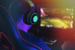 © Anastassiya  - Guy playing video games on computer under neon light.