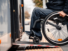 Person With A Physical Disability Enters Public Transport With An Accessible Ramp.