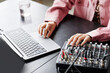 © Seventyfour - Close up of young woman using laptop while setting up recording equipment in studio, copy space