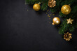 Black christmas background with fir tree and holiday decorations. Flat lay image with space for design.