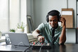 © Seventyfour - Portrait of African-American man setting up recording equipment in studio, copy space