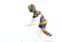 A Self-made Plaster Figure Was Partially Painted With Bright Colors And Walks Like Blind, With Arms Outstretched Forwards, In Front Of A White Background