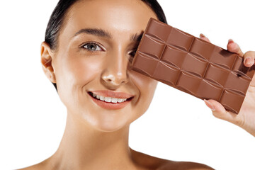 beautiful woman with makeup holding a chocolate bar on her face, isolated on white background. Spa chocolate mask