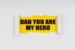 A window is made in the paper, where on a yellow background the inscription - Dad You Are My Hero